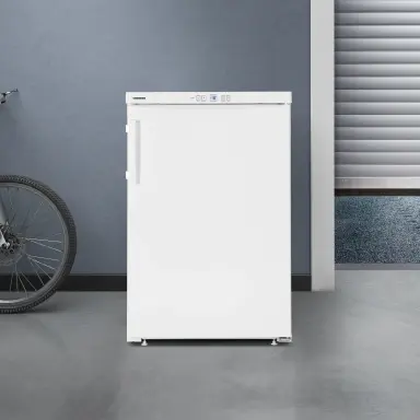 Frostprotect weißer Kühlschrank vor grauer Wand