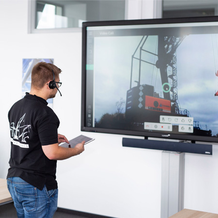 Person using a remote controller on a Liebherr machine.