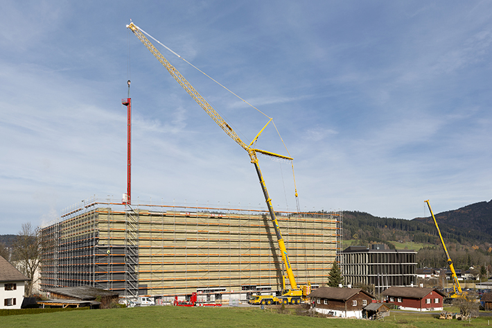 Liebherr LTM 1350-6.1 mobile crane installs storage and retrieval vehicles for high-bay shelving warehouse