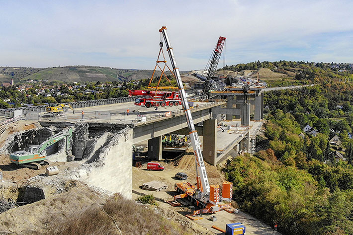 Liebherr crane hoists smaller partner out of bridge construction site