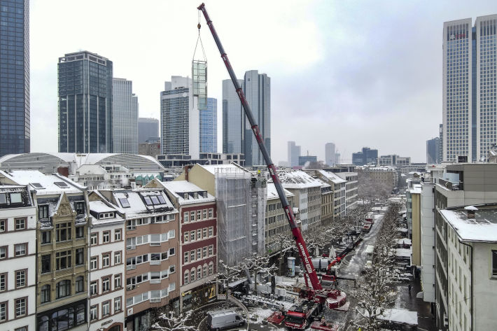 Liebherr LTM 1230-5.1 mobile crane installs elevator shaft against the backdrop of the Frankfurt skyline