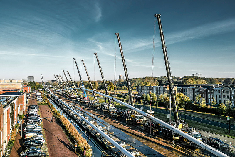 Twelve mobile cranes in operation during the construction of a pipeline in Delft