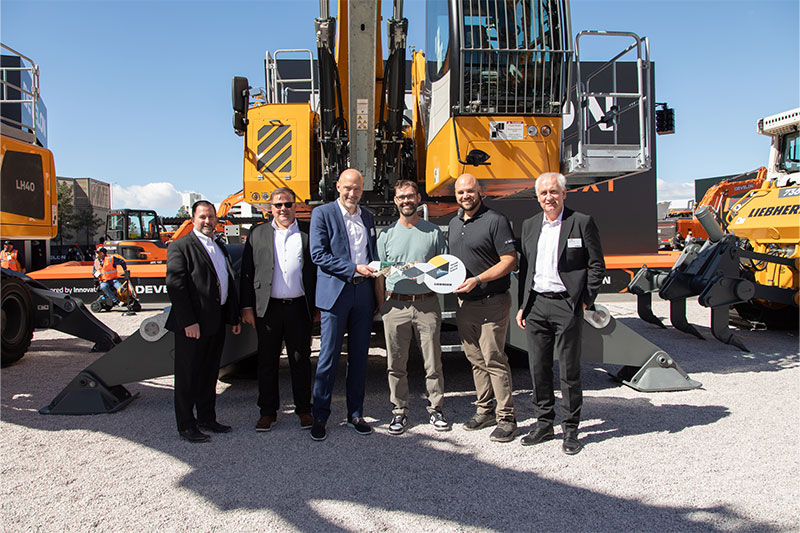 Nucor Raw Materials Group receives handover of a Liebherr LH 60 Industry E material handler at Conexpo 2026