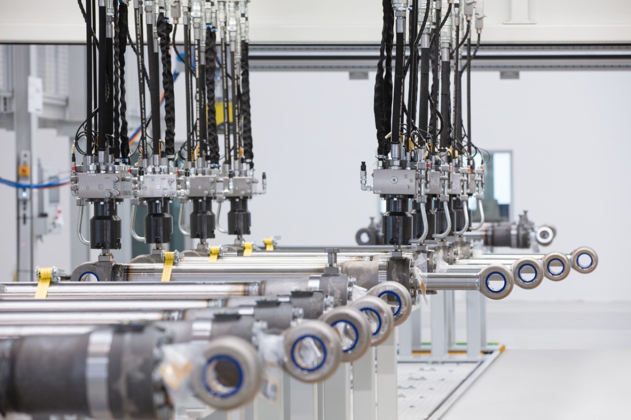 Ein Produktionsmitarbeiter prüft Hydraulikzylinderrohre von Liebherr