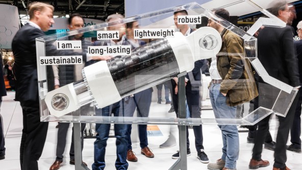 Menschen stehen um das Liebherr-Komponenten Exponat ein Schrottscheren-Zylinder auf der bauma 2025