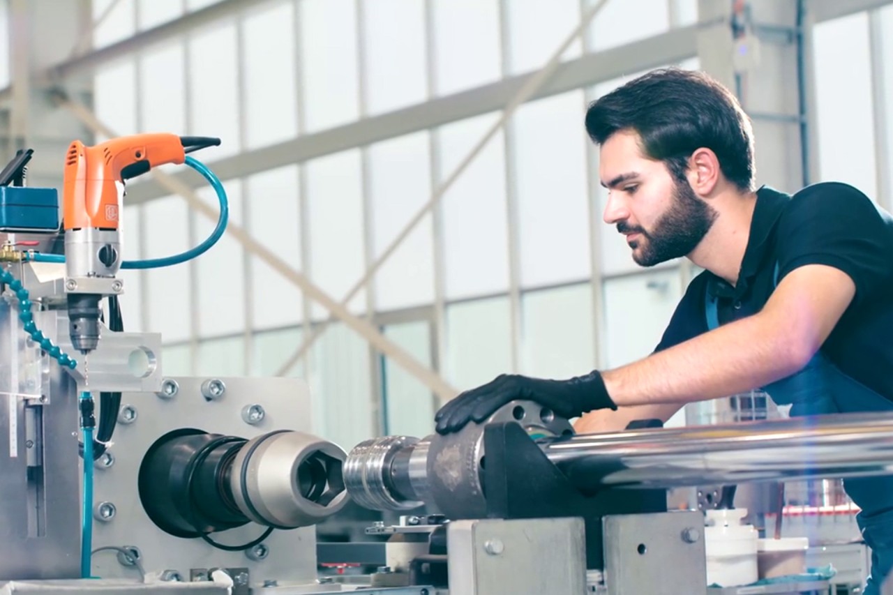 Ein Mann prüft einen Hydraulikzylinder auf dem Prüfstand von Liebherr