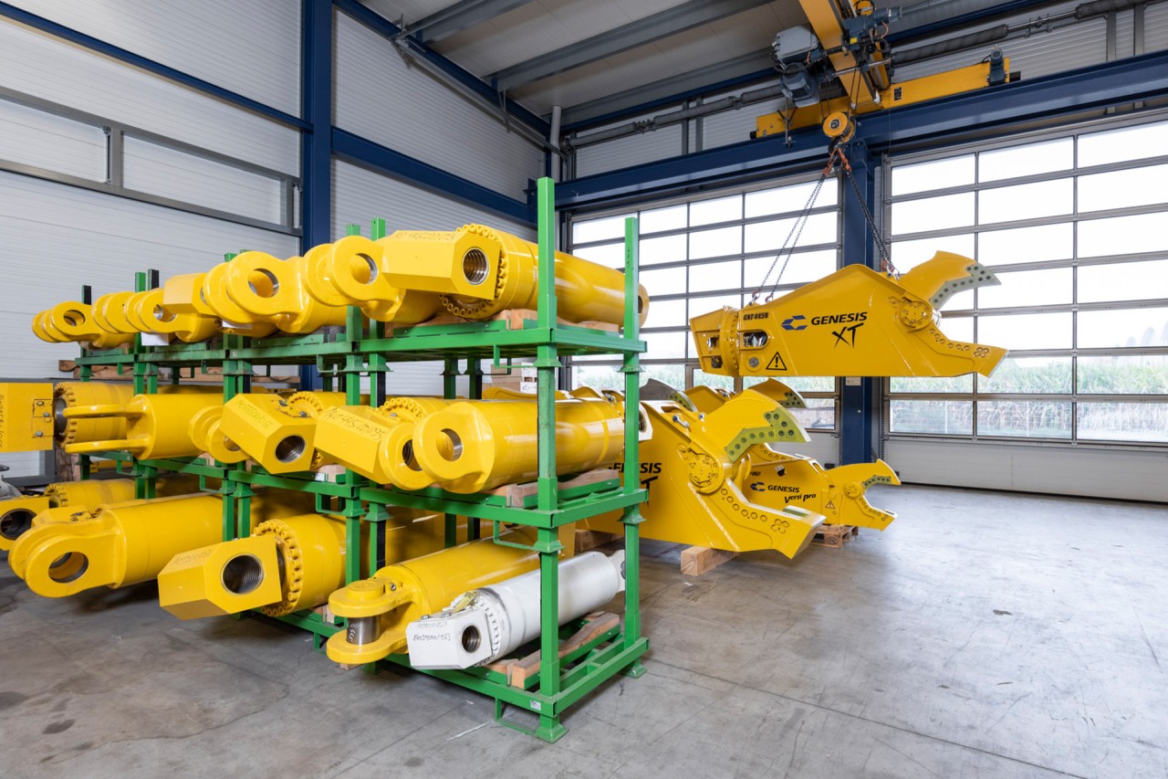 In einem Lager liegen mehrere Hydraulikzylinder für Schrottscheren