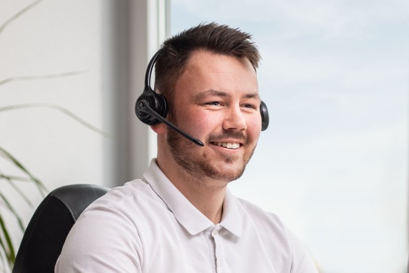 Male customer service representative wearing microphone headset and smiling 