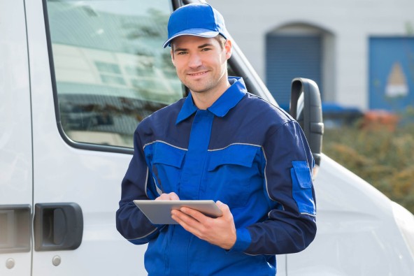 Liebherr service engineer standing in front of van holding tablet