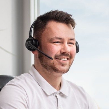 Male customer service representative wearing microphone headset and smiling 