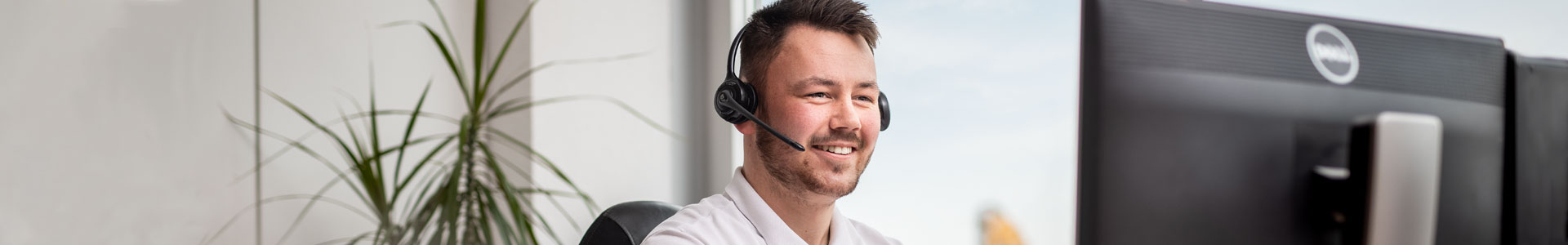 Male customer service representative wearing microphone headset and smiling 