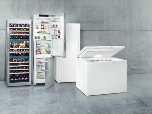 Wine fridge with glass door, silver fridge freezer with open doors, white freezer with closed door, and white chest freezer with open lid, against a grey background