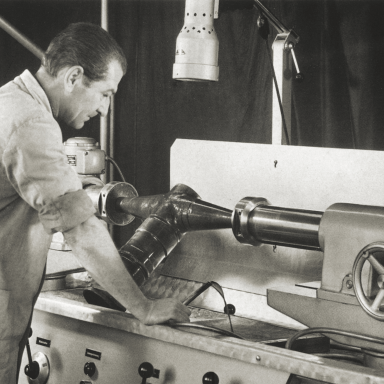 Factory worker looking over a machine