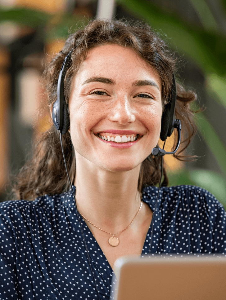 Smiling happy woman with a headset on and a laptop