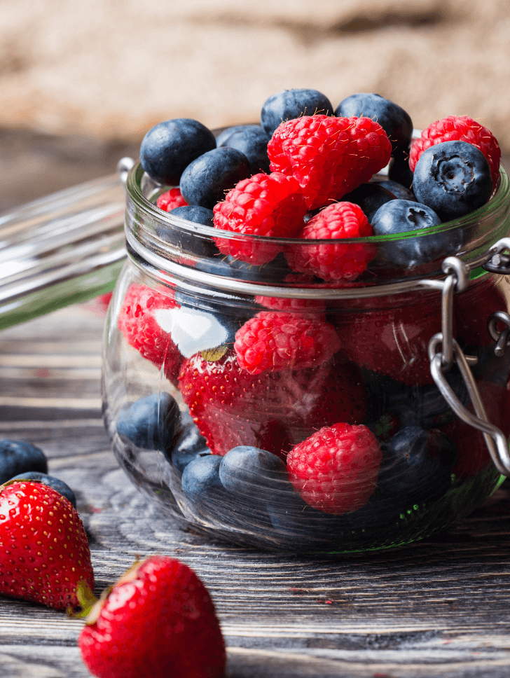 Over spilling berries in a glass jar