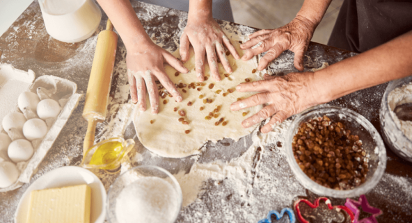 multiple people rolling out dough