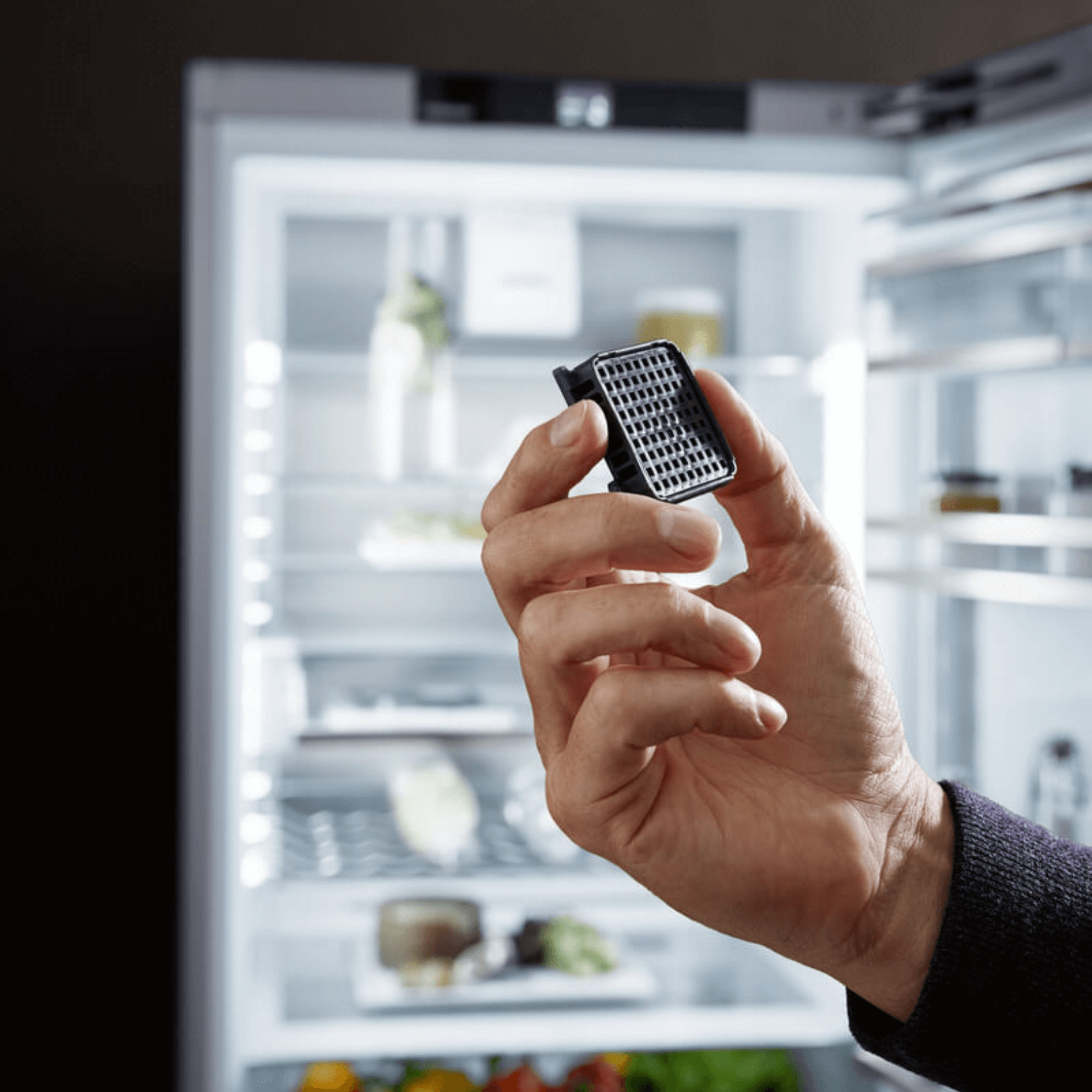 Close up of a charcoal filter with a fridge in the background 