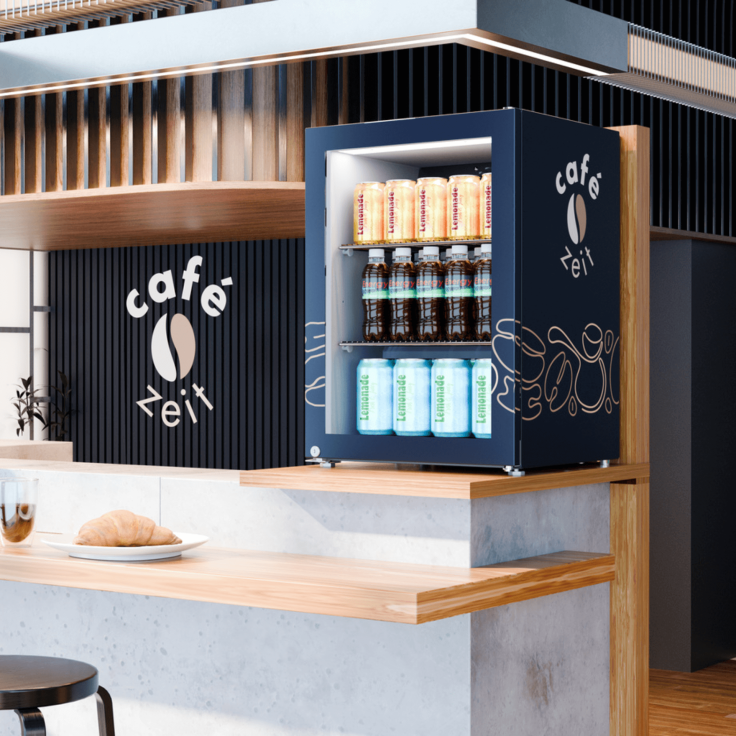 Small drinks fridge placed on caf? countertop with company logo on the side.