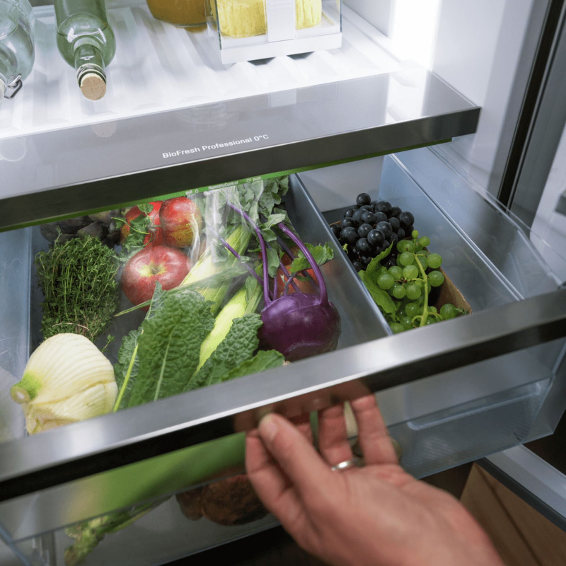 Pulled open BioFresh professional drawer with a cooling mist flowing over the fresh vegetables