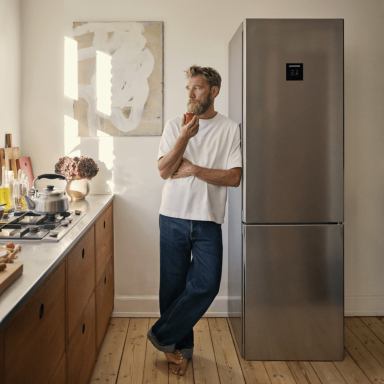 Mikkel Karstad leaning against his  Liebherr appliance CBNstb 579i holding an apple.