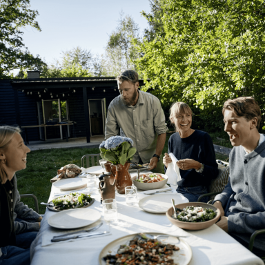 Mikkel Karstad and his family seated around a table set for dinner with prepared dishes