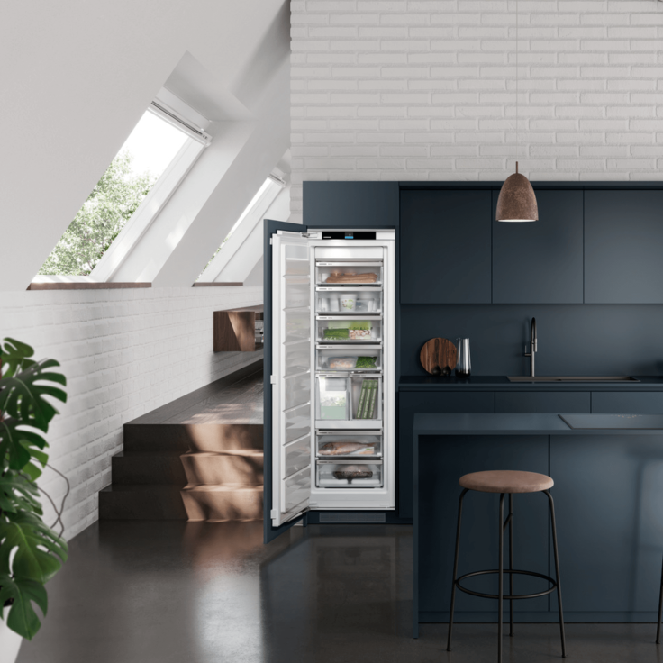 Open door freezer in an integrated blue toned kitchen 