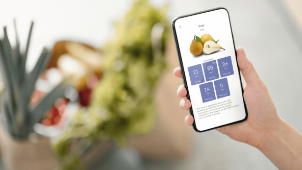 Close up of a phone showing a pear and how long it will last in a Liebherr appliance with blurred fresh food in bags in the background