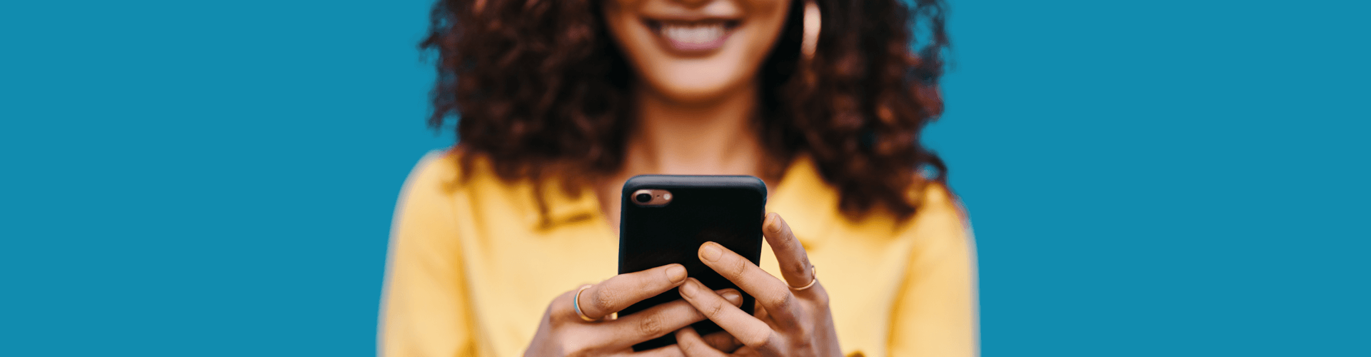 woman smiling at her phone