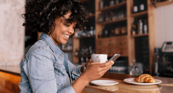 close up of woman looking at her phone smiling