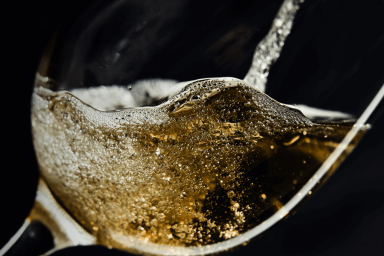 Tilted wine glass being filled with sparkling wine