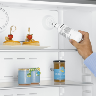 Close up of a person putting in their water filter into their fridge