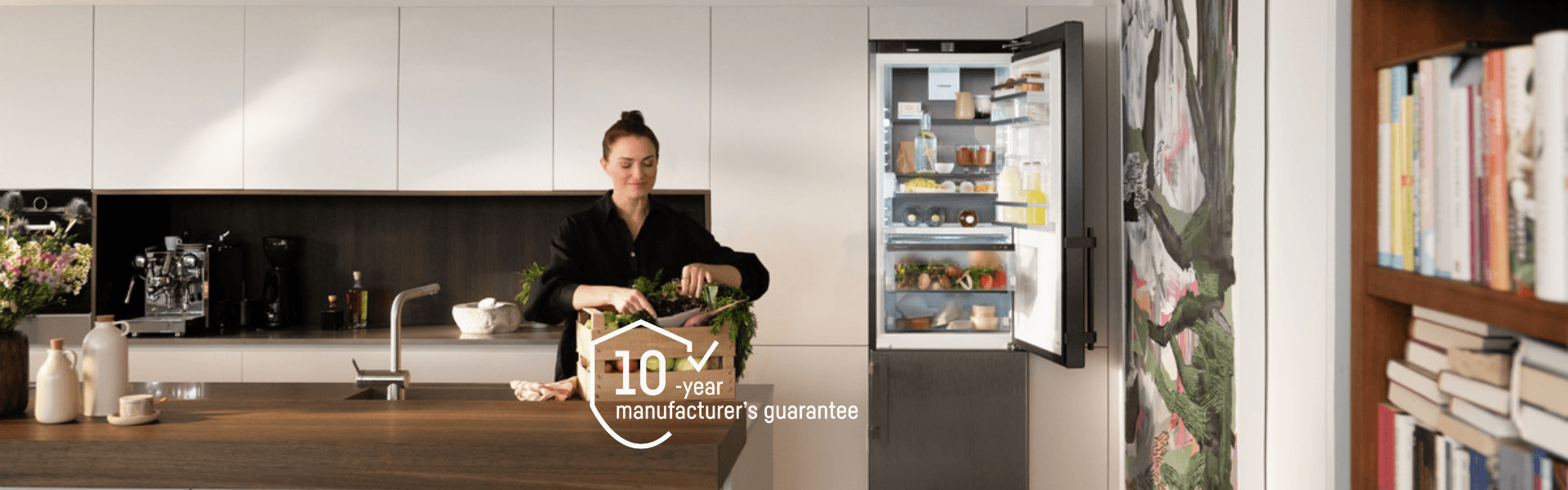 CBNbsa 575i fridge-freezer in Verena Konrad's kitchen Open door Liebherr fridge-freezer in a Verena Konrad's modern kitchen, showing her preparing fresh produce to go into her Liebherr appliance. With a 10-year logo showing that there is currently a free 10-year guarantee promotion.