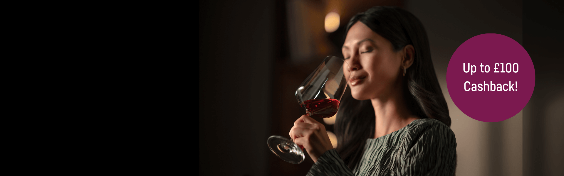 Serene woman sipping wine against a dark background, with focus on her face and expression - with a circle highlighting up to £100 cashback.