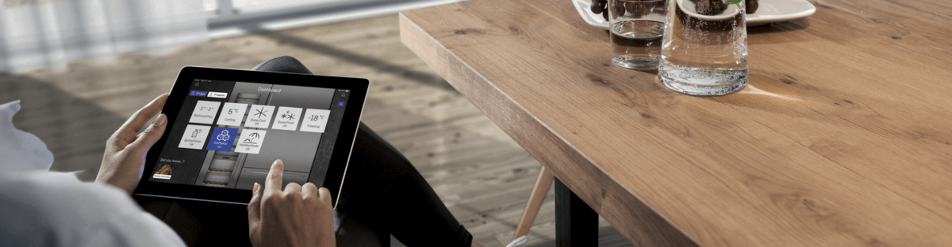 man looking at the smartdevice dashboard on a tablet whilst sitting at a table