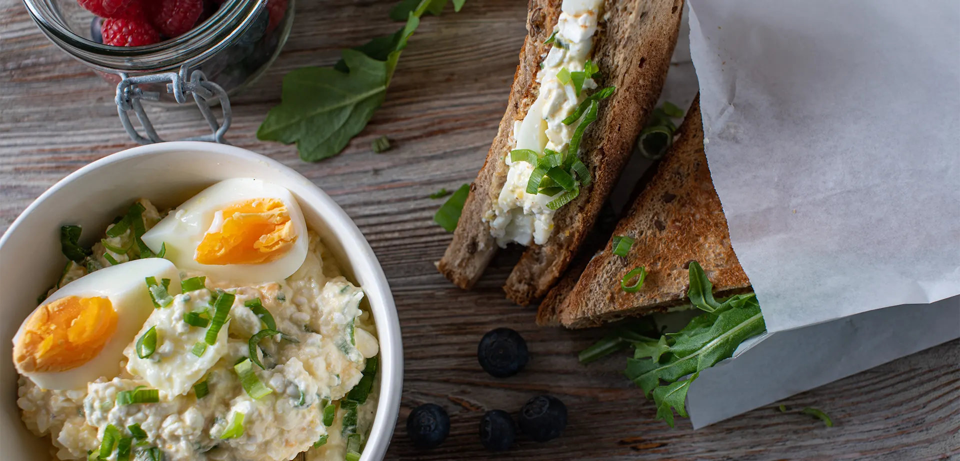 Proteinreicher Eiersalat mit gekochten Eiern und körnigem Frischkäse, serviert mit Vollkornbrot und frischen Beeren.