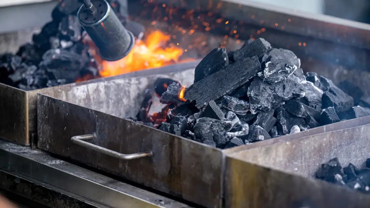 What role do fire, smoke, and roasted aromas play in fine dining? Wood that is burning and producing smoke on a barbecue.