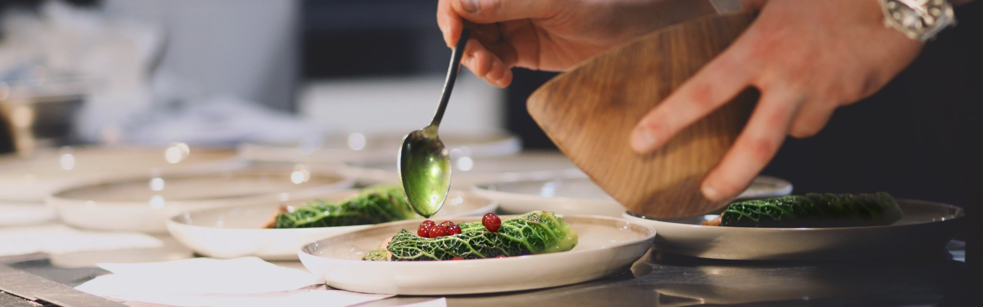 Fine dining trends: fermentation, fire, and tea A chef precisely spooning food onto a plate.