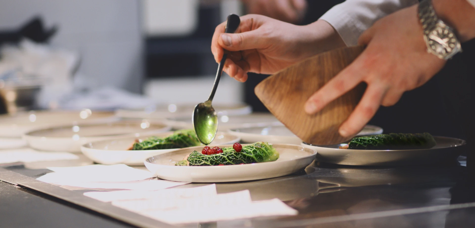 Fine dining trends: fermentation, fire, and tea A chef precisely spooning food onto a plate.