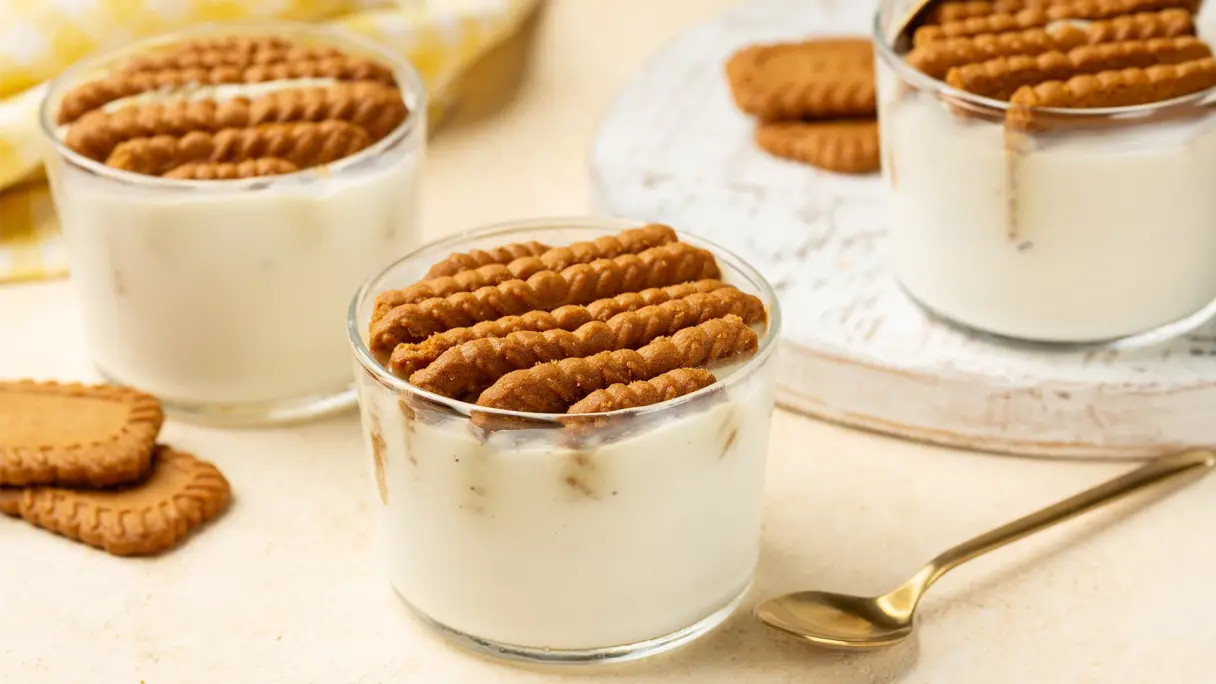 Japanese cheesecake: Viral dessert variant in a glass Three glasses containing creamy dessert and layers of caramel biscuits, arranged against a light background.
