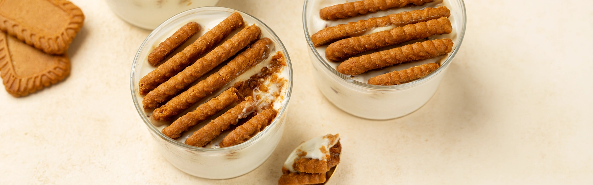 Japanese cheesecake: Viral dessert variant in a glass Three glasses with creamy dessert and layers of caramel biscuits against a light background.
