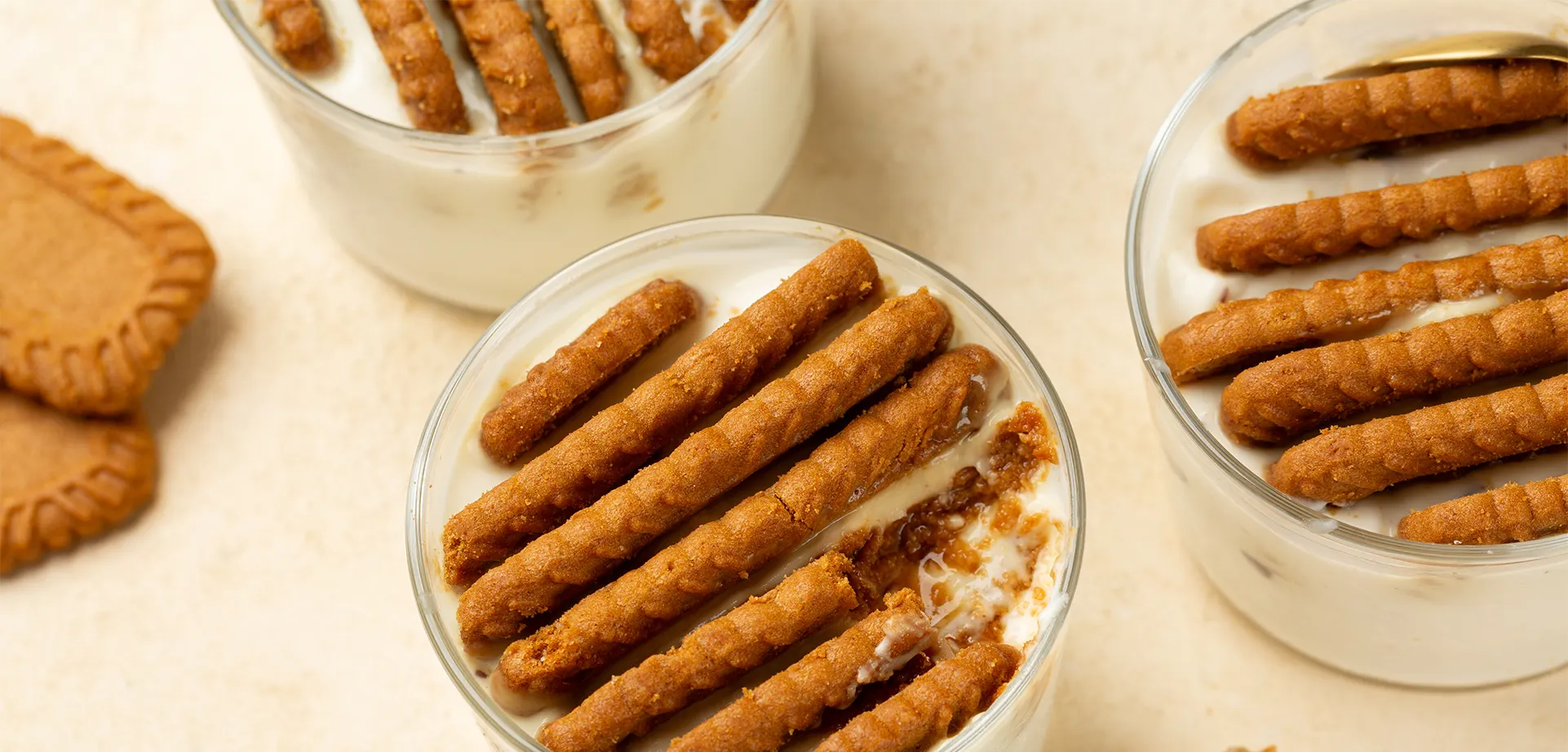 Japanese cheesecake: Viral dessert variant in a glass Three glasses with creamy dessert and layers of caramel biscuits against a light background.