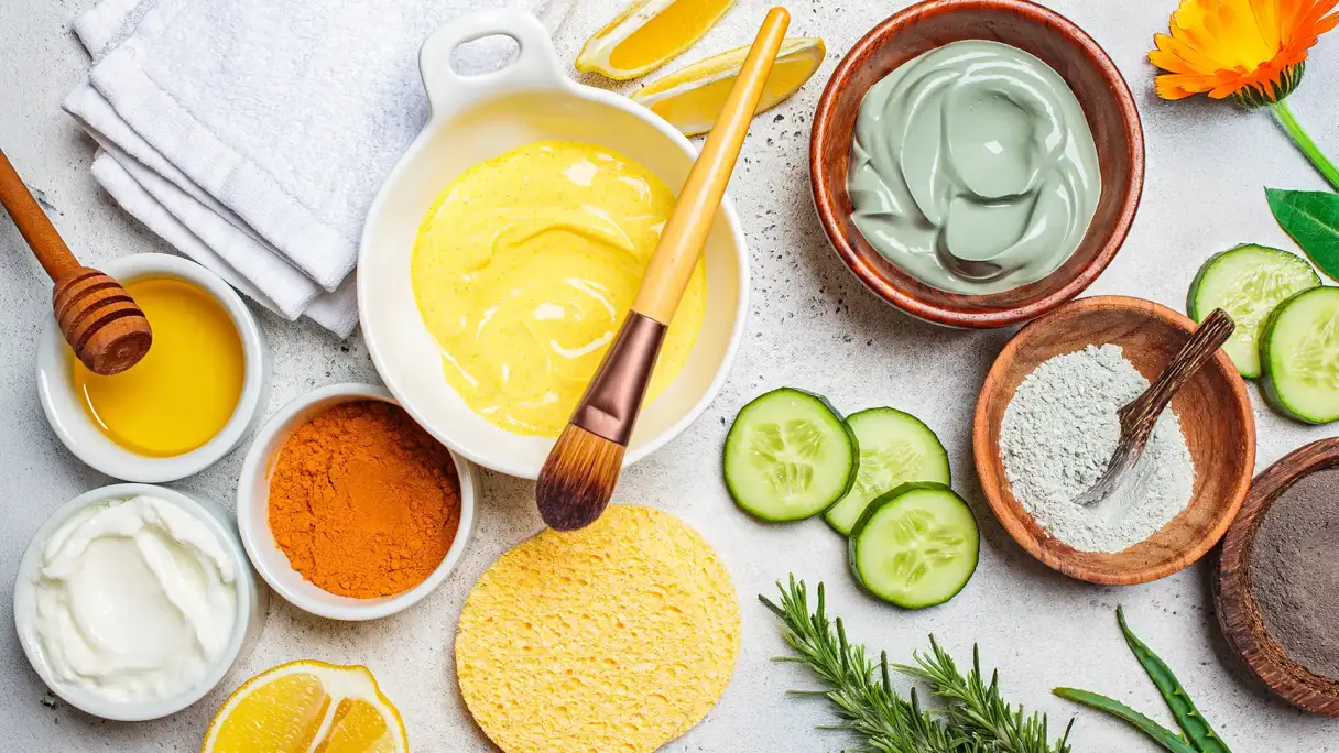 Verschiedene selbst gemachte Masken für gesunde Haut. Natürliche Inhaltsstoffe wie Gurke, Zitrone, Ringelblume und Rosmarin für die Gesichtspflege auf weißem Hintergrund.