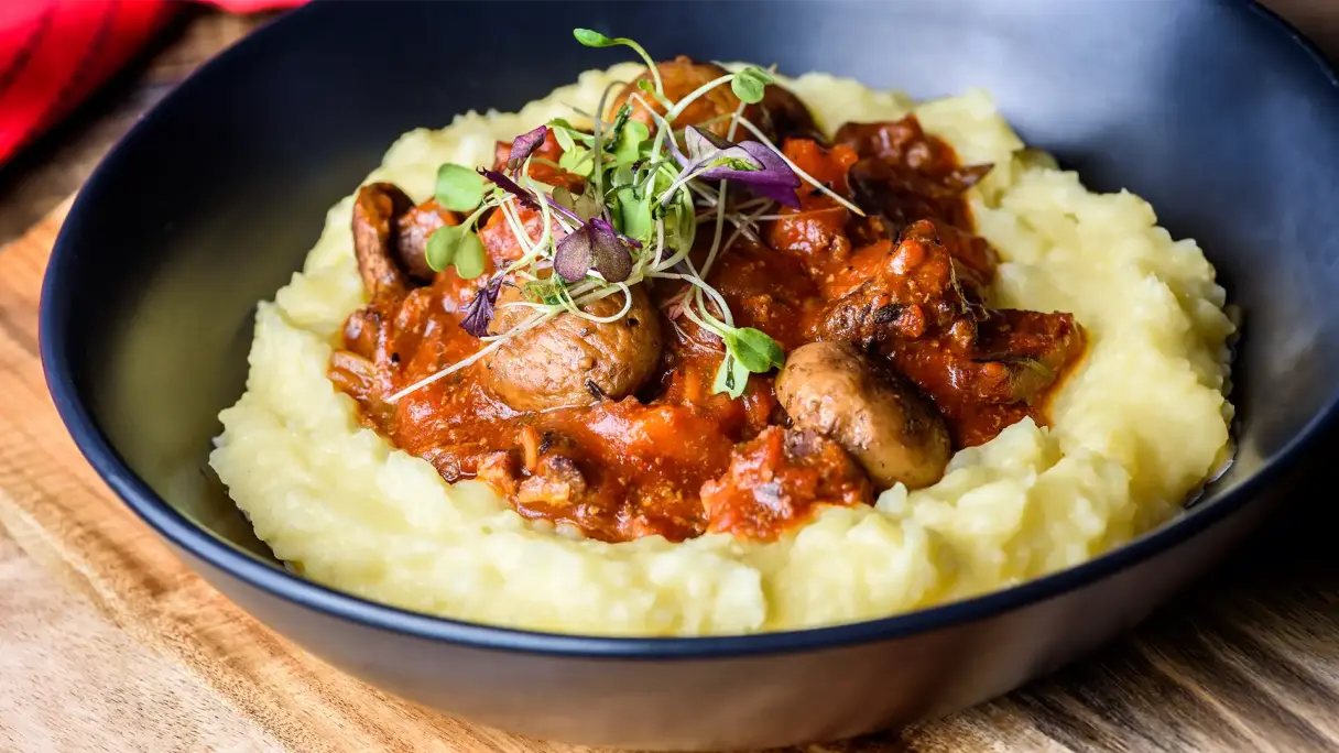 Boeuf bourguignon modern angerichtet Modern angerichtetes Boeuf bourguignon mit zarten Rindfleischstücken, Champignons und dunkler Sauce auf cremigem Kartoffelpüree.