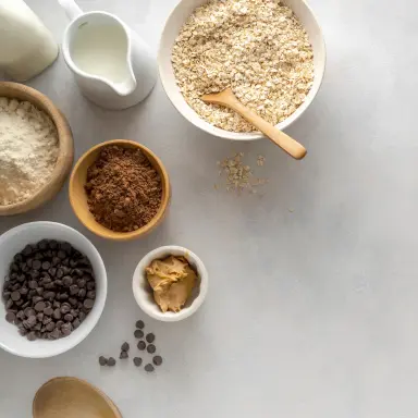 Nahaufnahme von Nussmus und dunklen Schokoladen-Tropfen in kleinen Schälchen