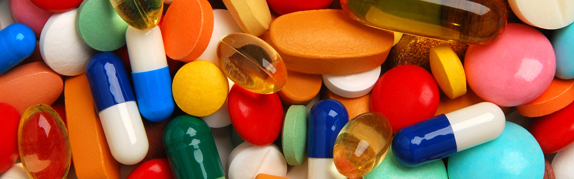 Sehr viele bunte Pillen liegen auf einem Haufen.