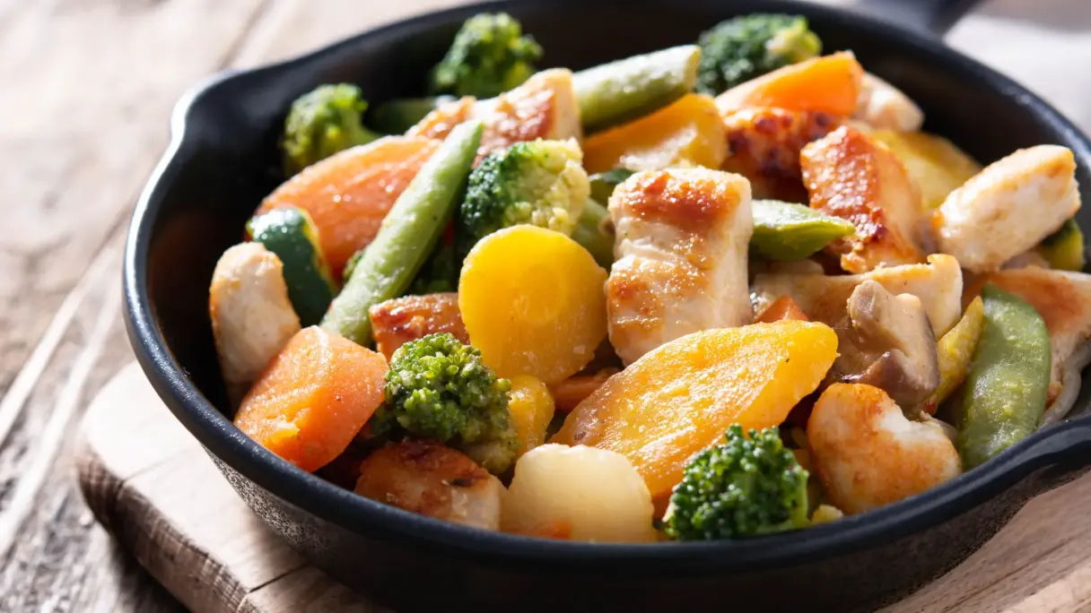 Chicken and vegetable stir-fry Stir-fried vegetables with chicken in a pan.