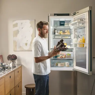 Mikkel Karstad in seiner Küche, vor einem Liebherr Kühlschrank.