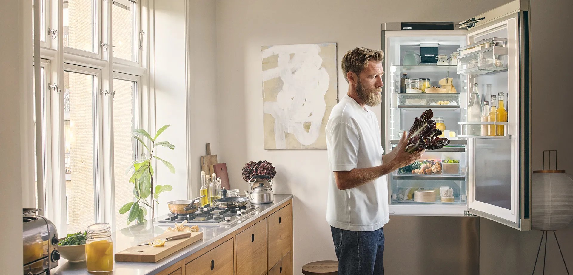 Mikkel Karstad in seiner Küche, vor einem Liebherr Kühlschrank.