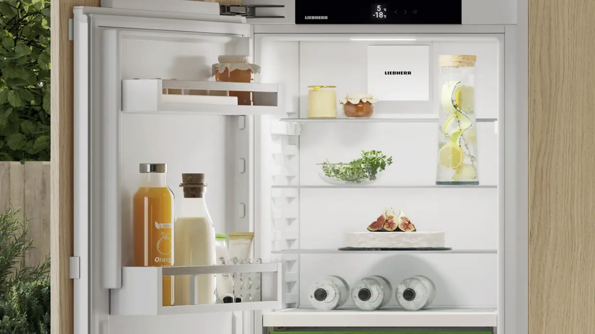 Offener Kühlschrank mit Milchpflasche in der Tür, daneben Saftflasche; zeigt korrekte Kühlung bei 5 °C für frische Milch.