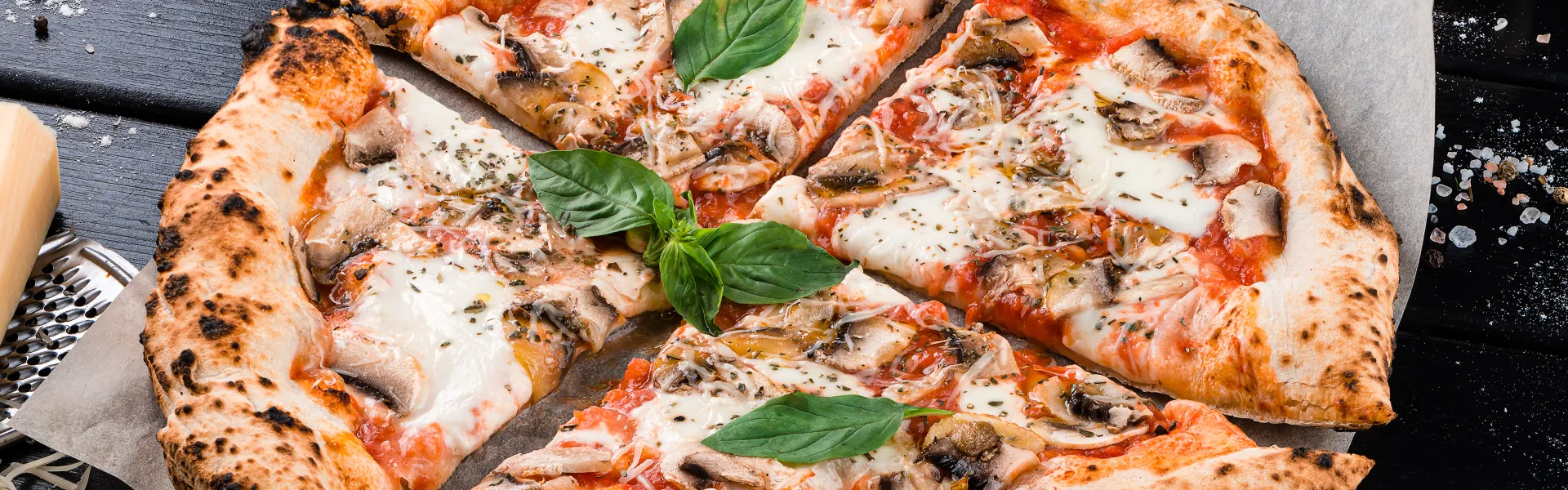 Gebackene Pizza mittig platziert auf einem Teller.